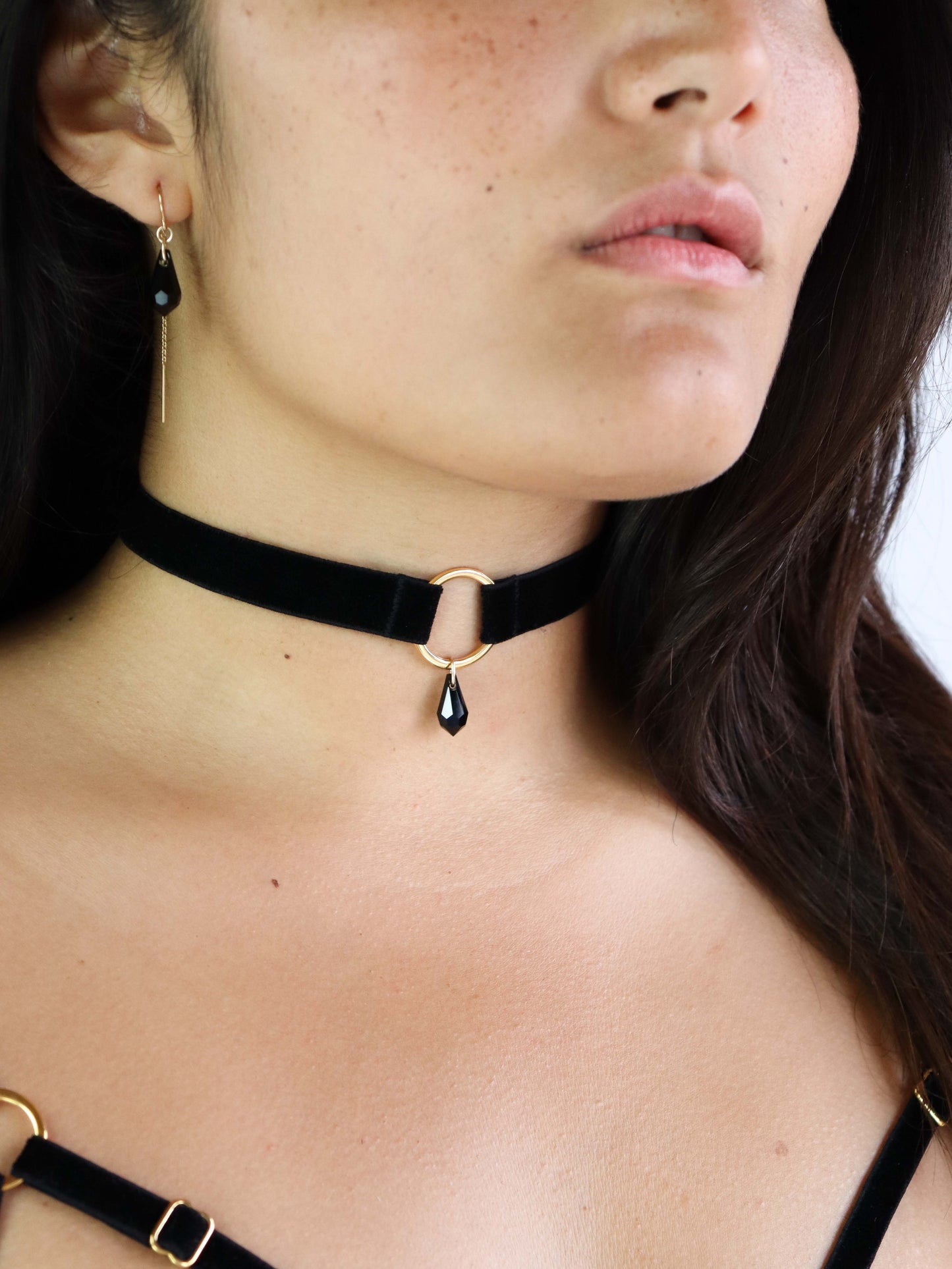 Adjustable Black Velvet Choker with gold o-ring charm attached to black Swarovski crystal pendant.