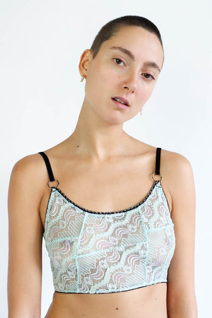 Light-blue lace crop top with pink details, black velvet straps and silver hardware. Size Small