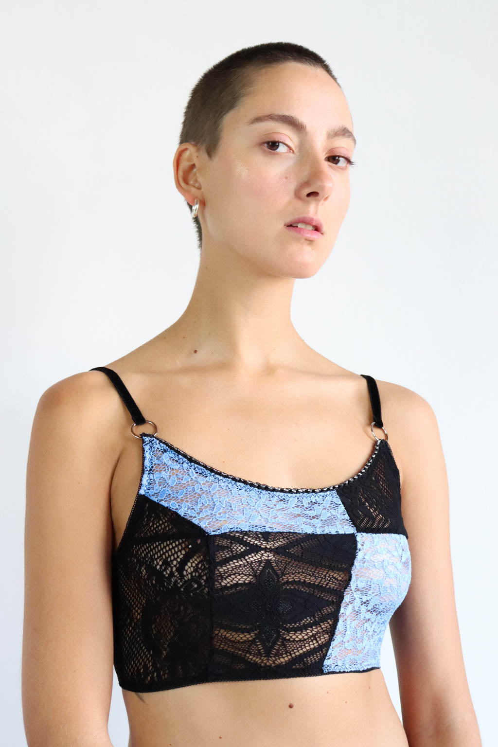 Black and light blue patterned lace crop top with adjustable velvet shoulder straps and silver hardware. Size Small.