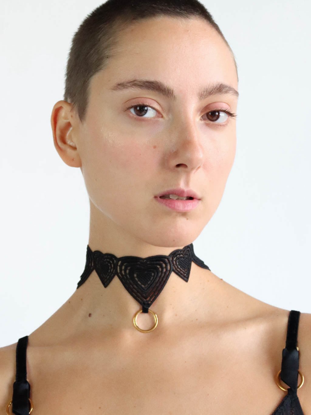 Black lace choker with heart shaped design and gold o-ring pendant. Sustainable lingerie accessory