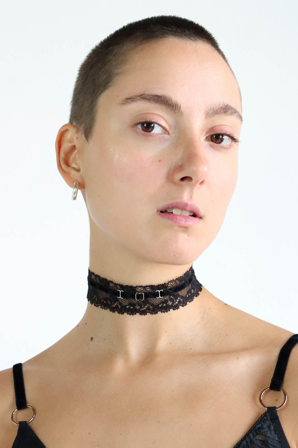 Close up view of a black lace and velvet choker with eco-friendly silver hardware