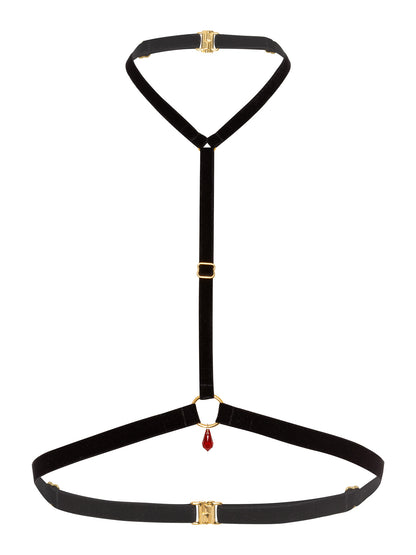 Gender free black chest harness made with soft velvet straps and a gold o-ring pendant with a red Swarovski crystal.