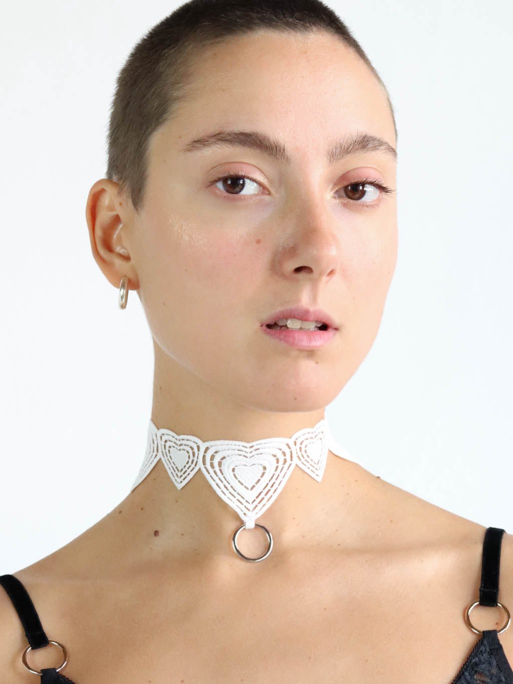 White lace choker with heart design and silver o-ring pendant. Unisex lingerie accessory.