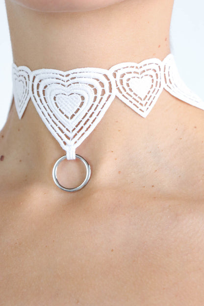 Close up view of a heart patterned white lace choker with an eco-friendly silver pendant.