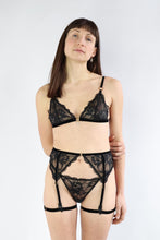 Load image into Gallery viewer, Woman wearing a 3 piece lingerie set, with black floral lace and gold hardware.
