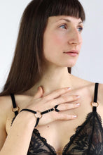 Load image into Gallery viewer, Portrait of a woman wearing a hand harness with velvet straps and gold hardware.

