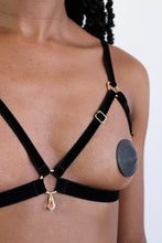 Load image into Gallery viewer, Close-up of a woman wearing an open cup bra harness with black velvet straps, gold hardware and a clear crystal pendant.
