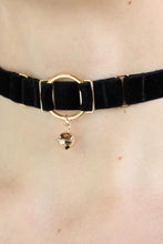 Load image into Gallery viewer, Close-up of a woman wearing an O-ring black velvet choker with a gold bell charm.
