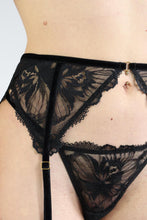 Load image into Gallery viewer, Close-up of a woman wearing a black floral lace garter belt, with gold hardware.

