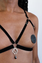 Load image into Gallery viewer, Close-up of a woman wearing an open cup bra harness with black velvet straps, silver hardware and a black crystal pendant.
