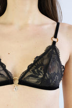Load image into Gallery viewer, Close-up of a woman wearing a bralette with black floral lace, gold hardware, and a transparent crystal pendant.
